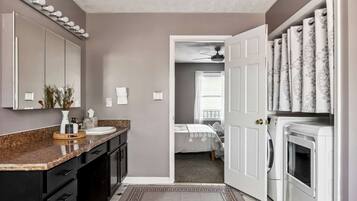A modern bathroom with a vanity, sink, mirror, and towel rack.