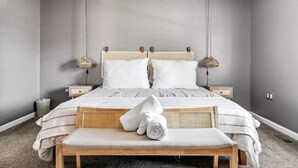 A bedroom with a bed, two bedside tables, a bench, and a hanging lamp. - Secluded Modern-Rustic Cabin with Hot Tub & Sunrise Old Rag Views near Shenandoah National Park, Luray VA (Luray)