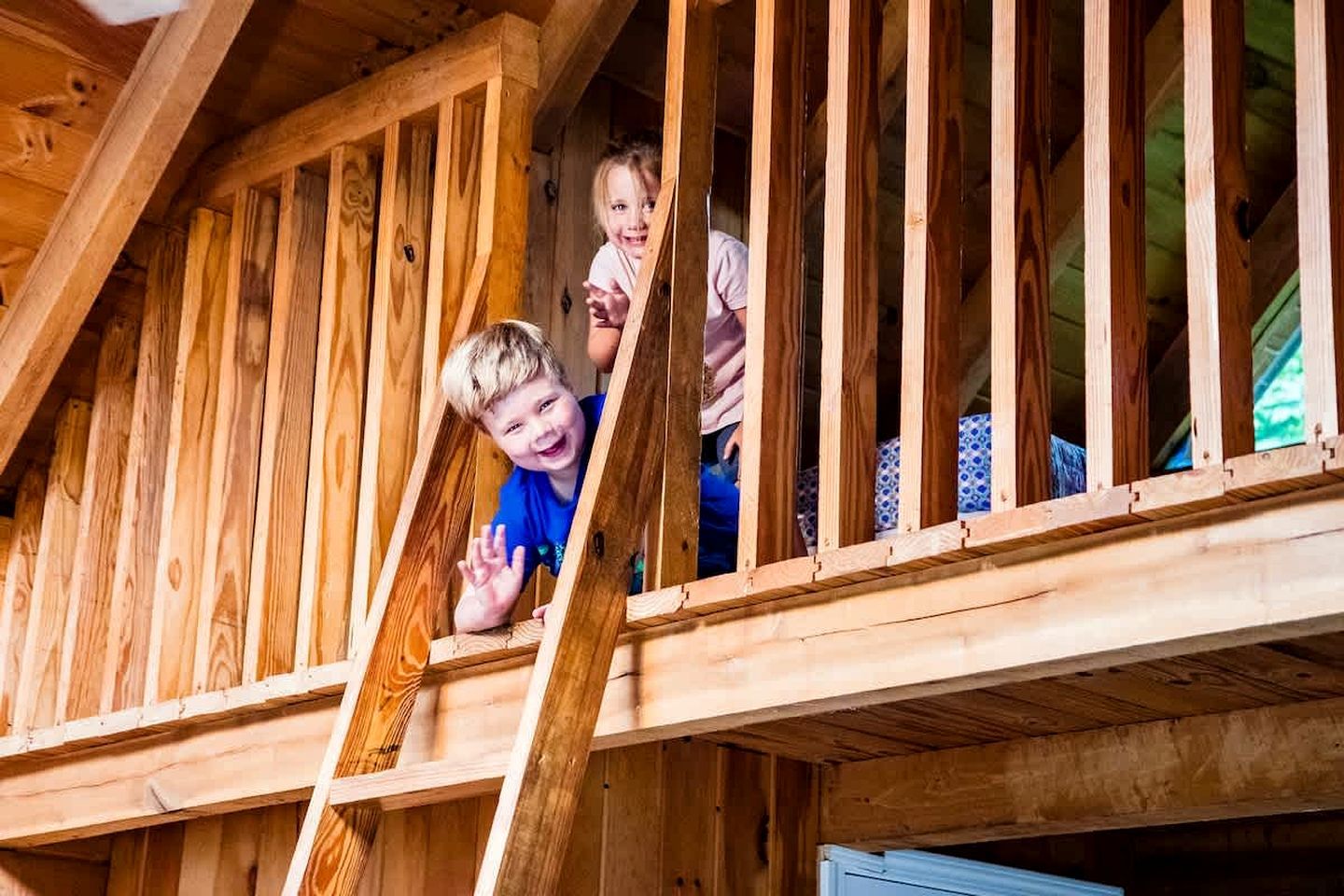 A wooden staircase leading to a lofted area with a sloped ceiling.