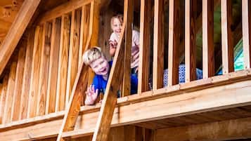 A wooden staircase leading to a lofted area with a sloped ceiling.