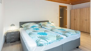A bedroom with a bed, nightstands, a wardrobe, and a ceiling with recessed lighting. - Apartment 'Auszeit im Grünen' with Mountain View, Shared Garden and Wi-Fi (Plaue)
