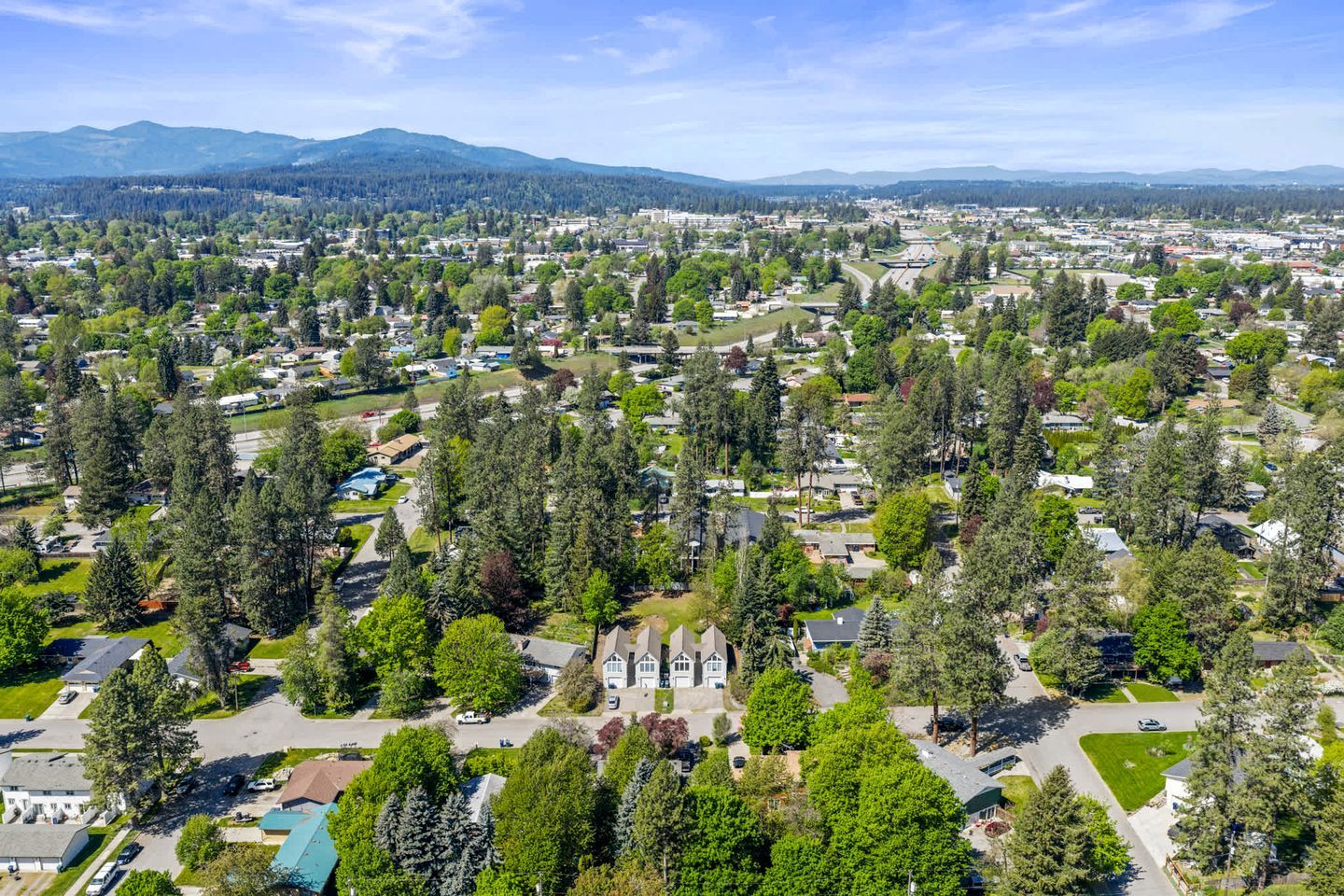 An aerial view of a residential area with houses, trees, and a church.
