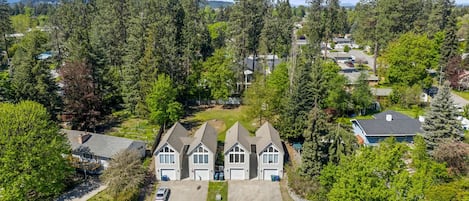 A residential area with a large house featuring a central driveway and multiple garage doors.