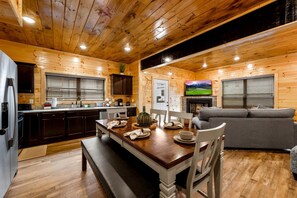 L’intérieur d’une cabane en bois comprend un coin repas, une cuisine et un salon.