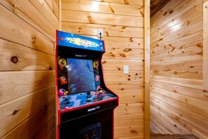 A wooden-paneled room with a single arcade game machine. - Stylish Pigeon Forge Cabin with Hot Tub, Pool & Dog Park near Dollywood and Gatlinburg, TN (Pigeon Forge)