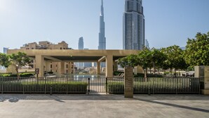Una plaza urbana moderna con vistas despejadas del Burj Khalifa y la Torre Emaar al fondo.