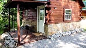 A log cabin with a porch, stone foundation, and a number '3' on the door. - Cozy Log Cabin near Cumberland Lake State Park, Perfect for an Outdoor Adventure (Columbia)