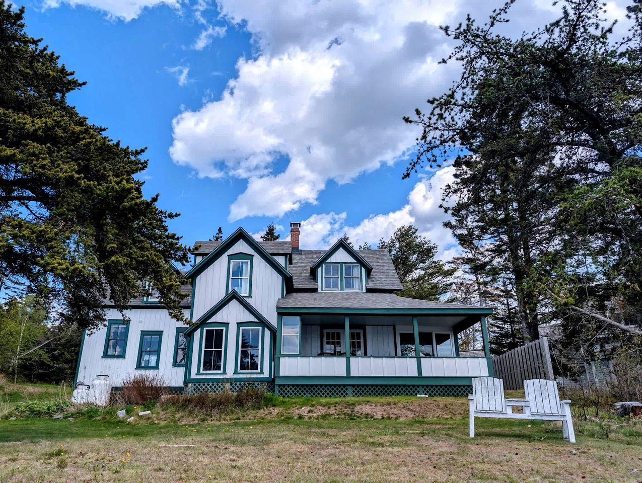 A two-story house with a porch and a small staircase leading to the entrance.