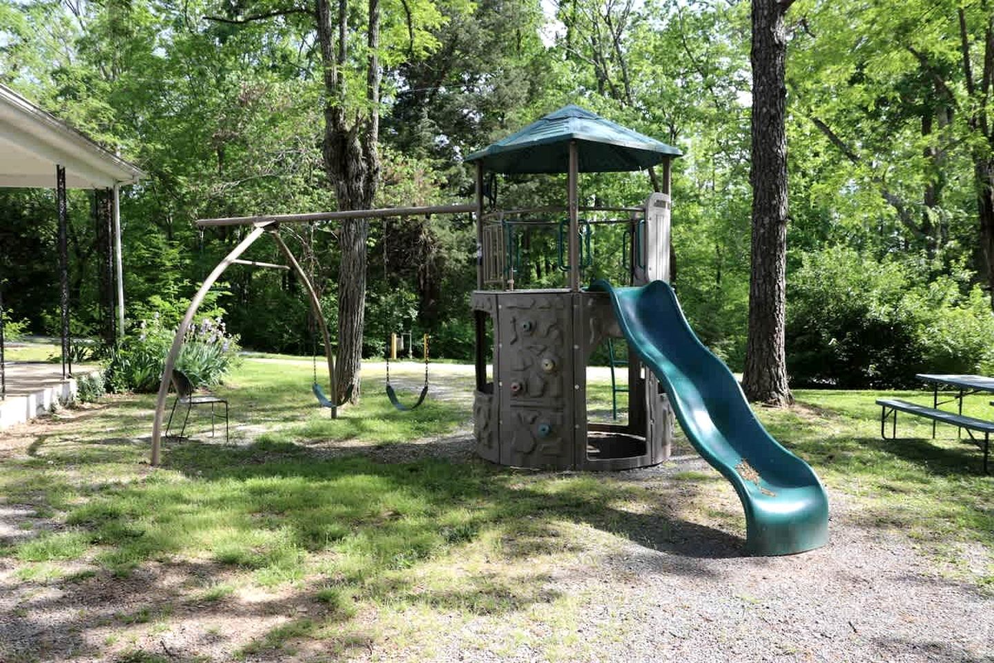 A playground with a slide, swings, and a covered play structure.