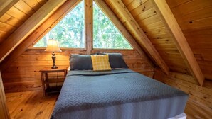 Une chambre de style « loft », avec un lit, une table de chevet et une fenêtre.