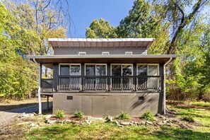 A two-story building with a balcony, surrounded by trees. - Spacious Riverfront Cabin with Private River Access Near Harpers Ferry | Harpers Ferry, West Virginia (Harpers Ferry)