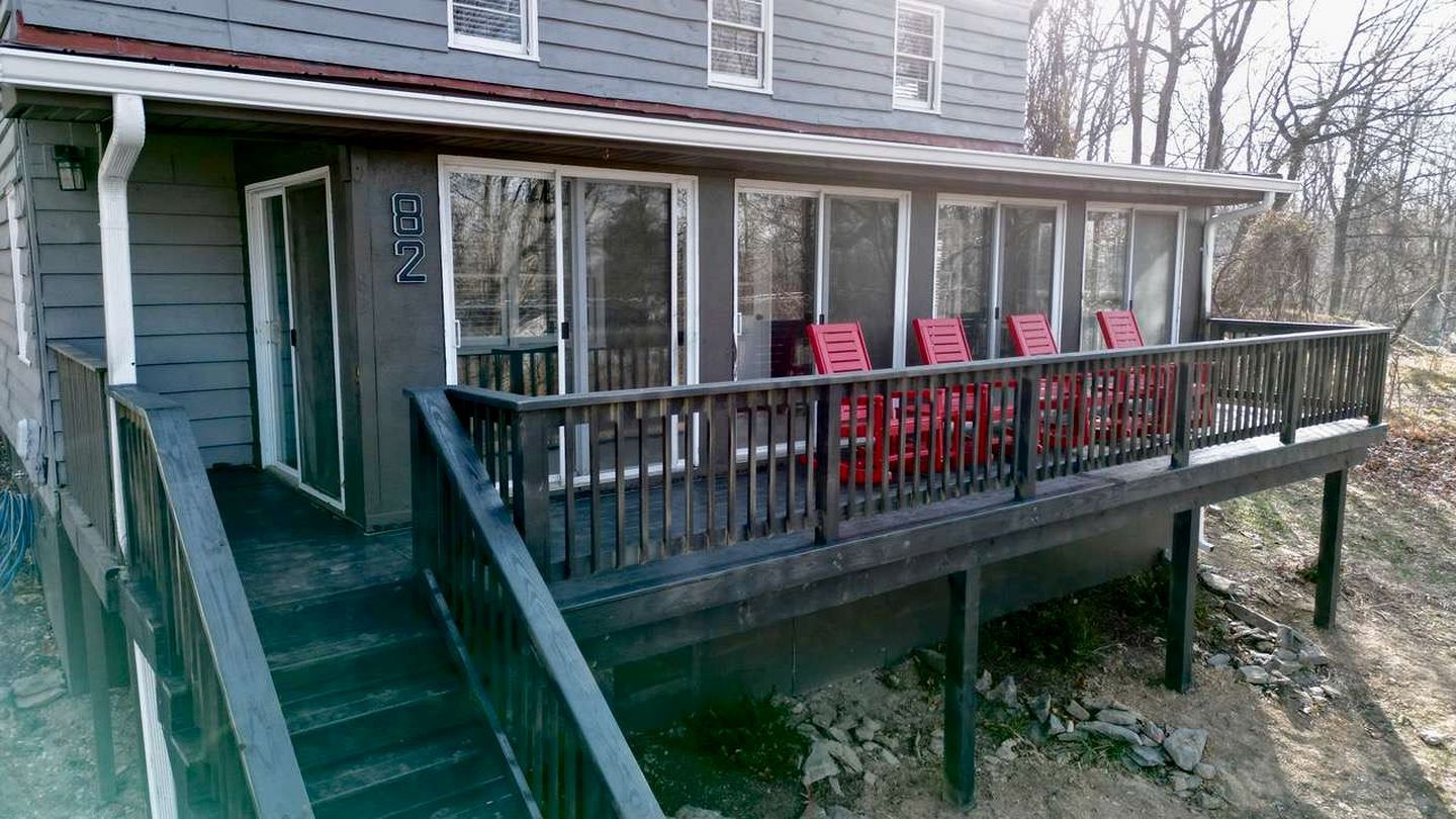 A house with a covered porch, a set of stairs leading up to it, and a number '82' on the wall.