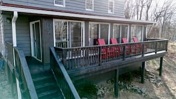 A house with a covered porch, a set of stairs leading up to it, and a number '82' on the wall.