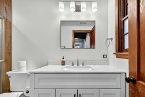 A bathroom with a white sink, a mirror, a toilet, and a shower door. - Spacious Riverfront Cabin with Private River Access Near Harpers Ferry | Harpers Ferry, West Virginia (Harpers Ferry)