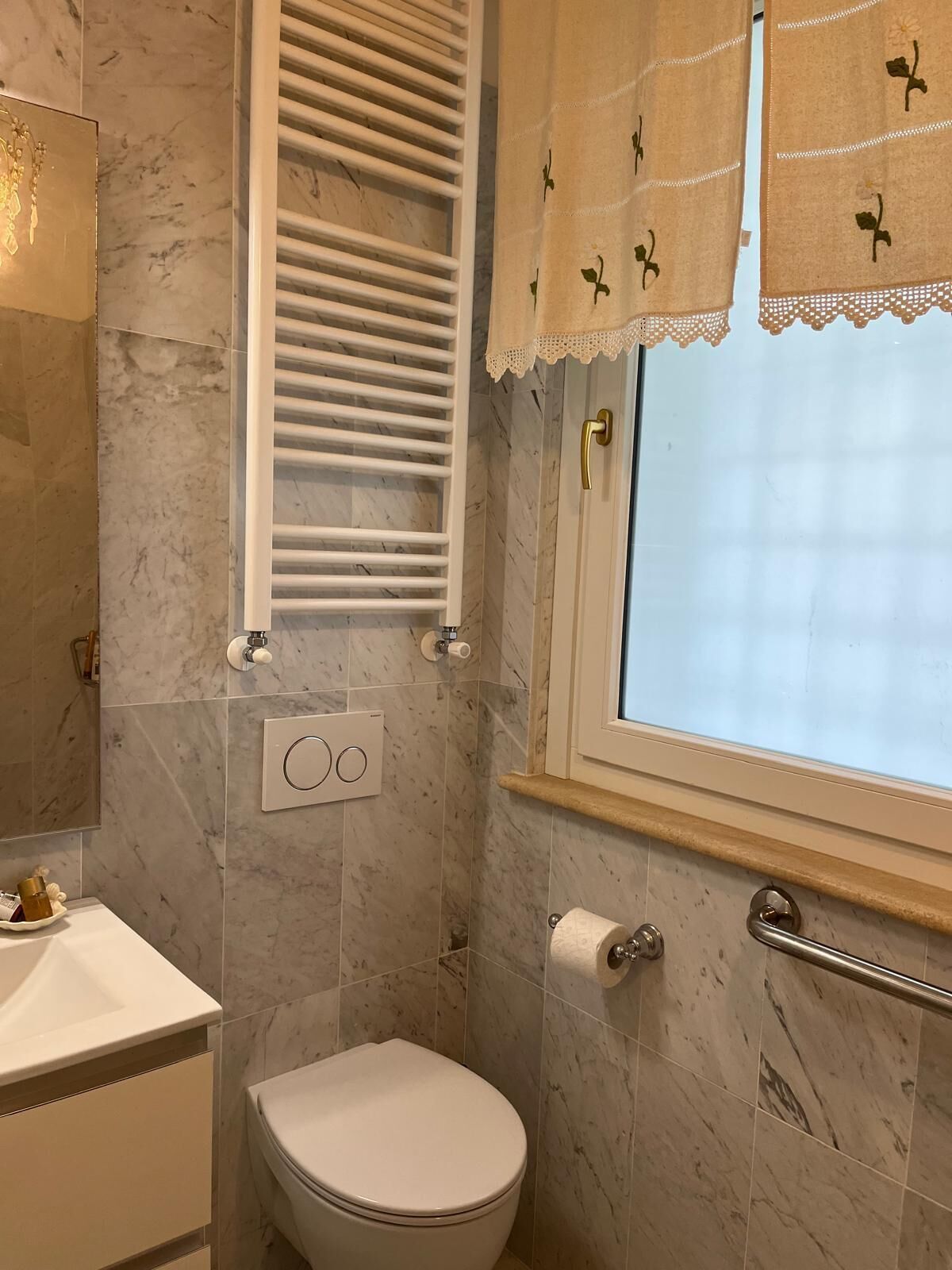 Une salle de bain comprenant des toilettes, un porte-serviettes, une fenêtre avec vue et un espace douche.