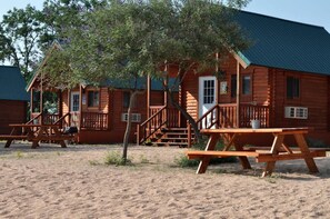 A wooden cabin with a porch, a picnic table, and a staircase leading to the entrance. - Escape to a Scenic Lakeview Cabin Near Waterfalls, Vineyards & Starry Nights in Buchanan Dam, Texas (Buchanan Dam)
