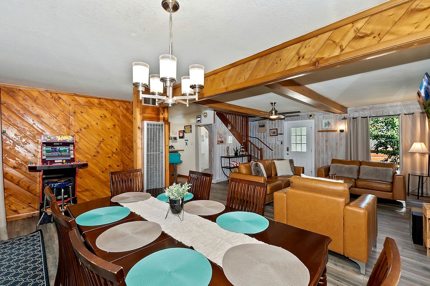 A dining area with a wooden table, chairs, and a chandelier.