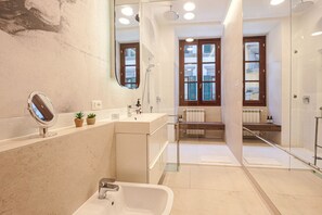 Ein modernes Badezimmer mit Badewanne, Waschbecken, Spiegel und Duschbereich.
