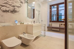 A bathroom with a bathtub, toilet, and a large mirror. - Apartments Florence - Charming Sant'Egidio (Florence)