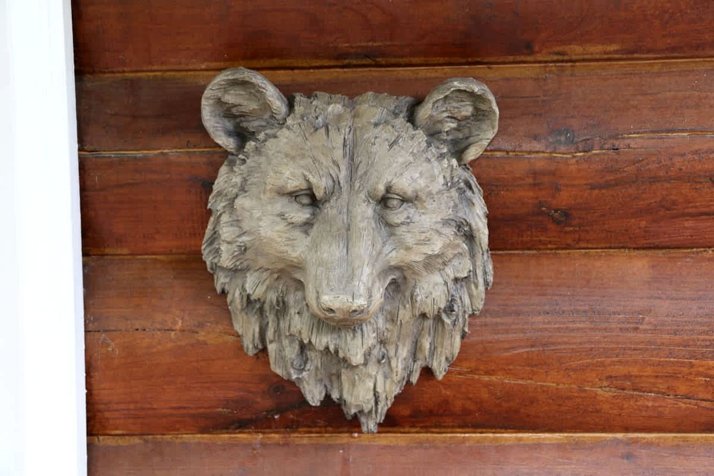 A wooden door with a carved animal head.