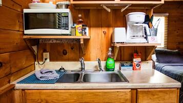 A compact kitchen with a microwave, sink, and coffee maker.