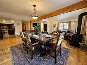A spacious dining area with a wooden table and chairs, a rug, and a fireplace. - Beautiful Vacation Rental with Creek Running Through the Property for a Relaxing Getaway in Nature in Breckenridge, Colorado (Breckenridge)