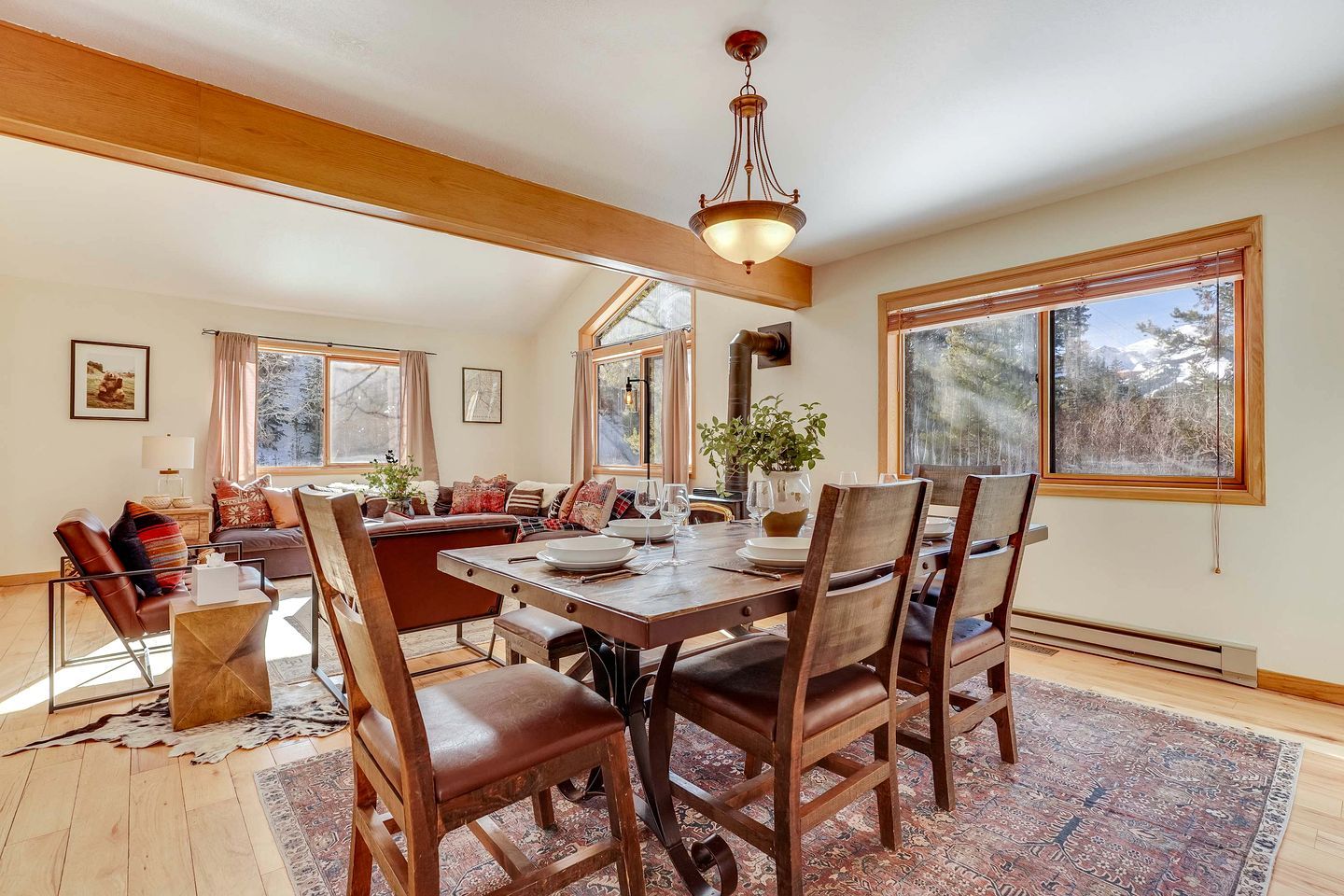 Un coin repas avec une table en bois, des chaises et un lustre.