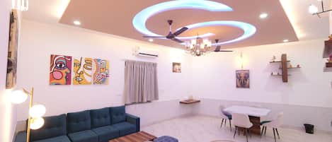 A modern living room with a sofa, coffee table, and dining area.