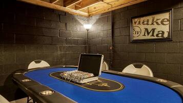 Ein Pokertisch mit Stühlen, ein Laptop und ein gerahmtes Schild an der Wand.