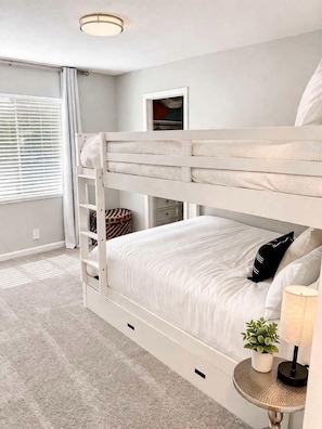 A bunk bed with a ladder, a bedside table with a lamp, and a small plant. - Relaxing Northern Nevada Home with Outdoor Patio Located Near the Keystone Trail in Reno, Nevada (Reno)