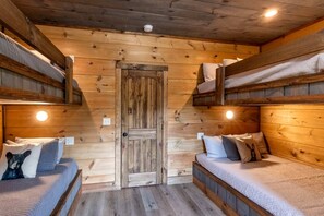 A cabin with two bunk beds, a wooden door, and a small window. - Spacious Luxury Cabin with Game Room near Pigeon Forge Attractions – Gatlinburg, TN (Gatlinburg)