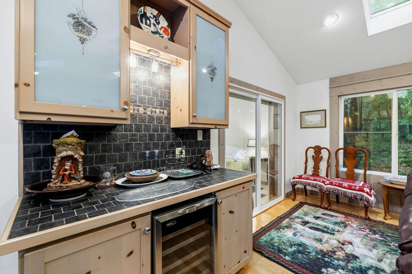 A kitchen with a stone backsplash, wooden cabinets, and a dishwasher.