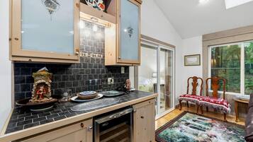 A kitchen with a stone backsplash, wooden cabinets, and a dishwasher.