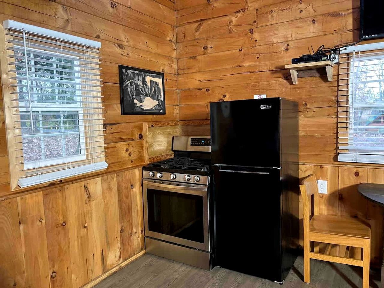 A kitchen with wooden walls, a stove, oven, and a refrigerator.