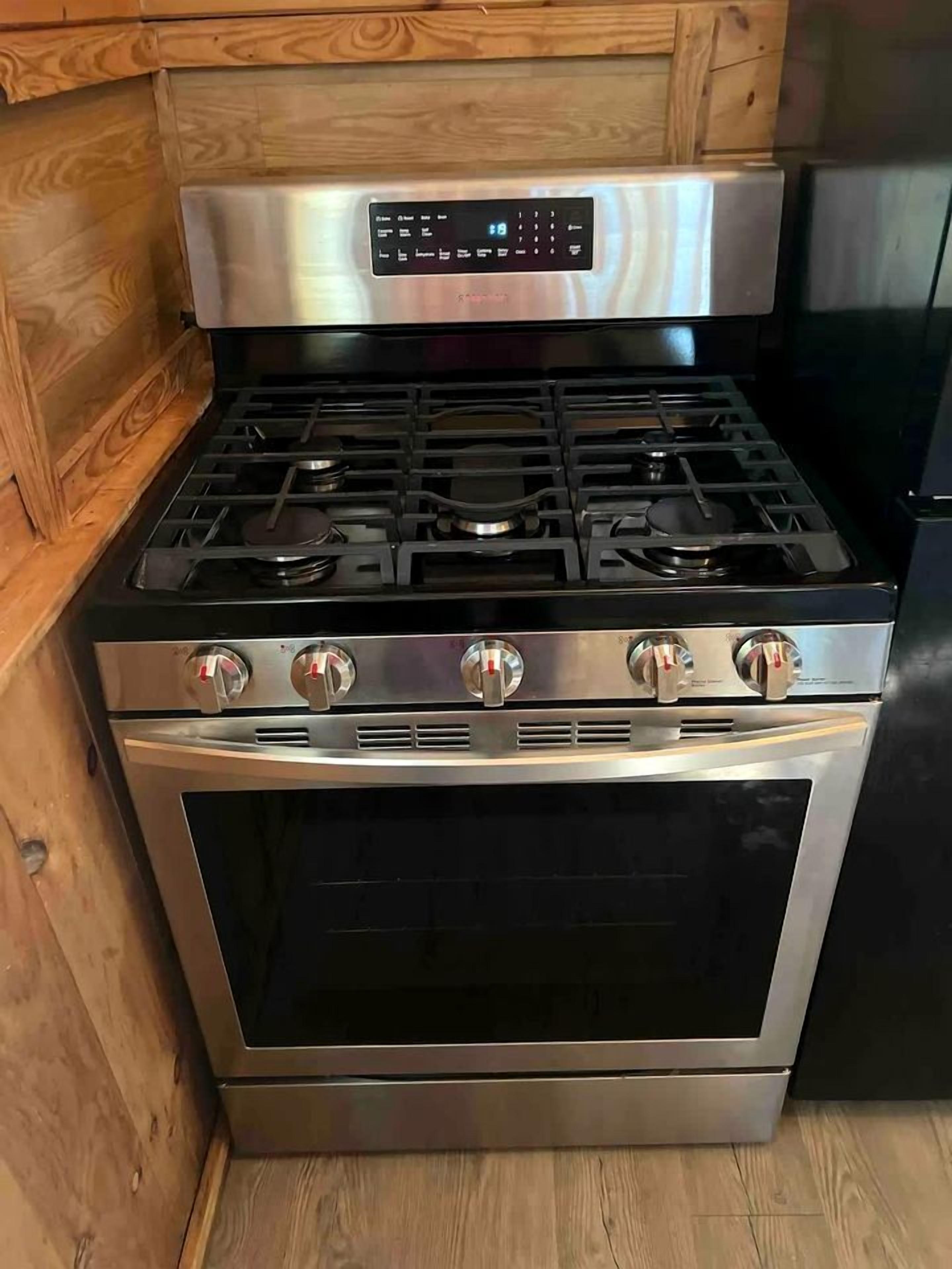 A stainless steel kitchen with a built-in oven and a digital control panel.