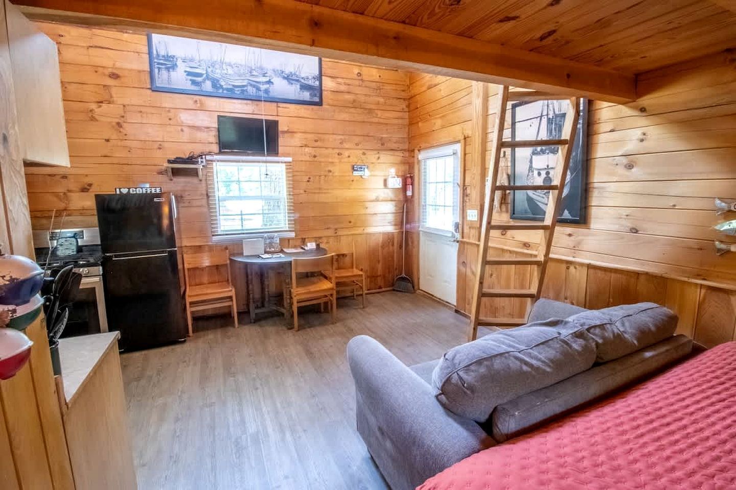 A cabin with a kitchen area, a dining table, and a sofa.