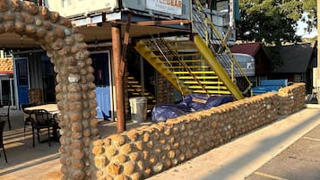 Un petit restaurant de rue appelé « Little Bear », doté d’une terrasse et d’un mur en pierre.