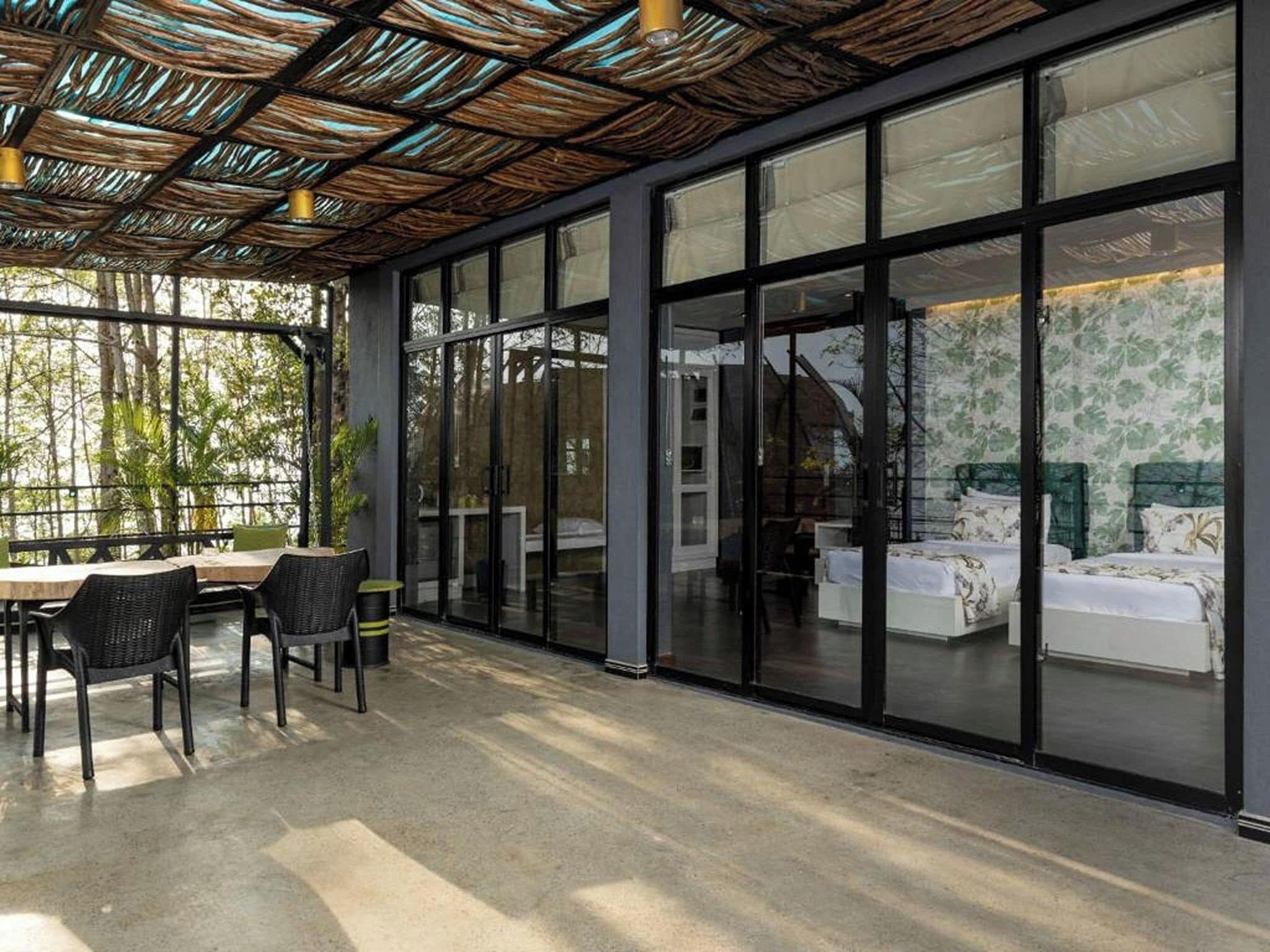 Un intérieur moderne comprenant un coin repas, un lit et de grandes fenêtres.
