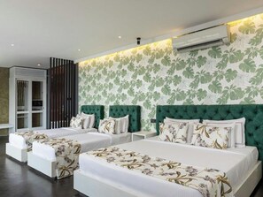 A hotel room with three beds, a large window, and a wall with a leafy pattern. - Green Acres Leisure Resort (Kadigamuwa)