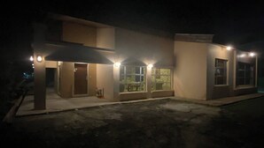 A modern building with a flat roof, large windows, and exterior lighting. - Urban Living in Kampung Setting (Kuching)