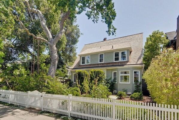 A two-story house with a white picket fence, surrounded by trees and greenery. - Terrific 6-bedroom house with AC in peaceful Historic downtown Palo Alto (Palo Alto)