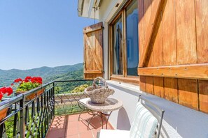 A balcony with a wicker table and chairs, a wooden fence, and potted plants. - A very spacious villa in Rapallo, situated in the hills just a 10-minute drive from the sea. Spanning 270 sqm across 3 independent levels, the villa accommodates up to 16 guests, making it ideal for large groups or families. The outdoor area offers every (Rapallo)