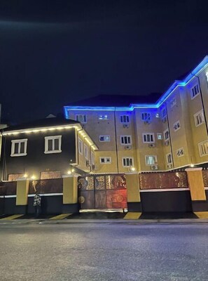 En bygning med flere etager og en lukket indgang, oplyst af udvendig belysning.