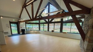 A spacious room with a high ceiling, large windows, and a wooden floor. - Large vacation rental for 15 people with a private pond • 45 minutes from Mont Saint-Michel (Landéan)