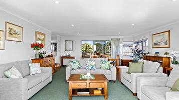 A spacious living room with two sofas, a coffee table, and a dining area with a table and chairs.