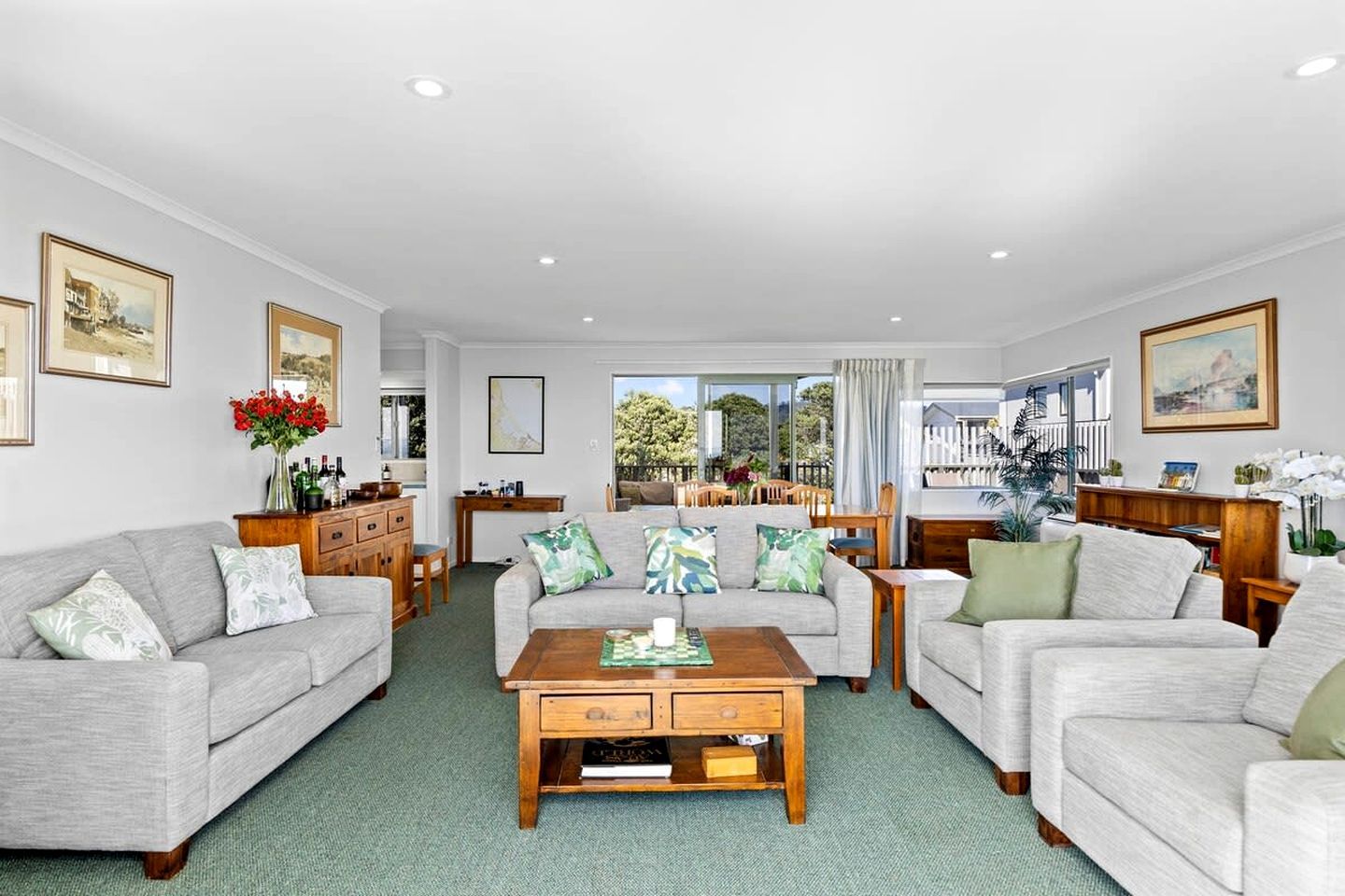 A spacious living room with two sofas, a coffee table, and a dining area with a table and chairs.