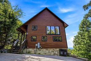 A wooden cabin with a stone foundation, a porch, and a staircase leading to the entrance. - Stunning Mountain View Cabin with Hot Tub & Game Room near Pigeon Forge, Sevierville TN (Sevierville)