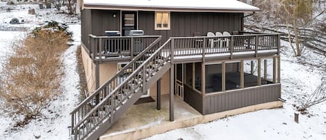 A two-story building with a balcony, a staircase, and a covered outdoor area.