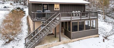 A two-story building with a balcony, a staircase, and a covered outdoor area.
