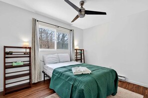 A bedroom with a bed, a ceiling fan, a window, and a nightstand. - Spacious Mountain Retreat with Hot Tub & Screened Porch Near Wineries and Appalachian Trail | Harpers Ferry, WV (Harpers Ferry)